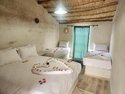 a bedroom with two beds with flowers on them at Les Jardins d Amizmiz 6 piscines in Marrakech