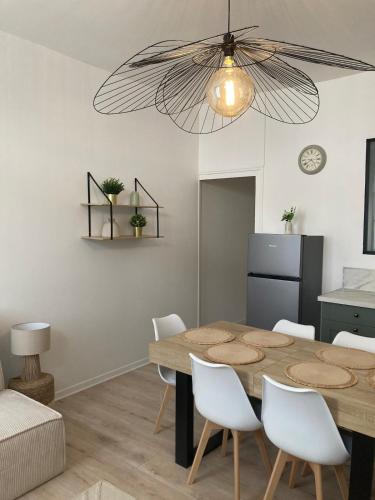 une salle à manger avec une table et des chaises blanches dans l'établissement Le grand nid charmant, à Azay-le-Rideau