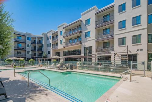 a swimming pool in front of a apartment building at Spacious 2BR Uptown Biltmore Gym Pool Parking WD in Phoenix