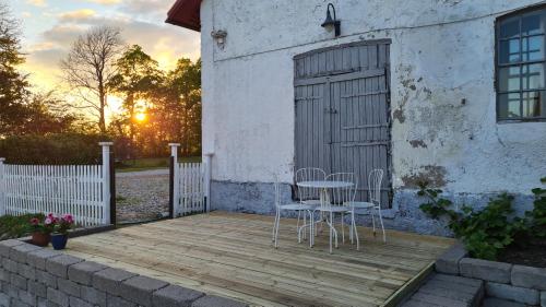 two chairs and a table on a wooden deck at Spacious & elegant apartment in a stable at Kvarnviks Gård in Klagstorp