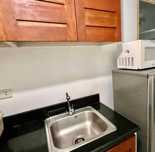 a kitchen with a sink and a refrigerator at Makati Business District Prime Accommodations in Manila