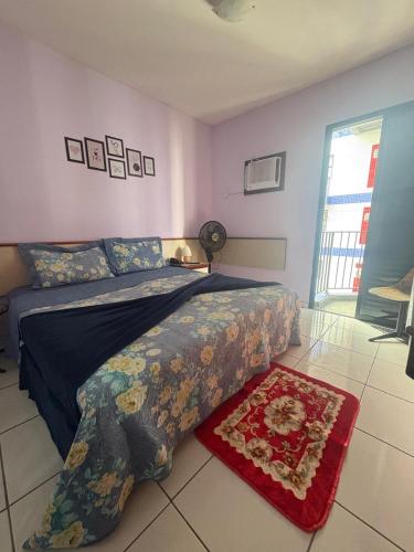 a bedroom with a bed and a red rug at Flat Palladium in São Vicente