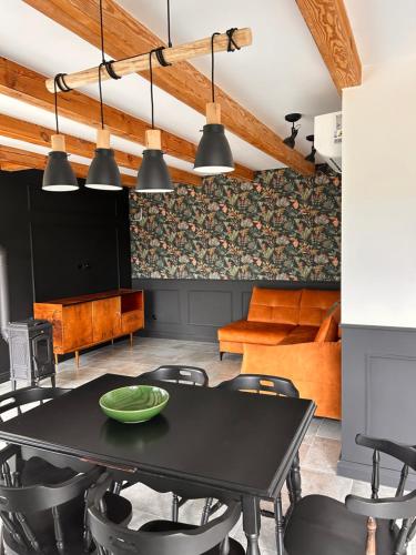 a dining room with a black table and chairs at Powidoki Mazury in Płociczno