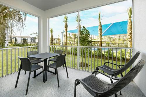 a balcony with a table and chairs and a view at Villatel Orlando Resort, Apartments by Marriott Bonvoy in Orlando
