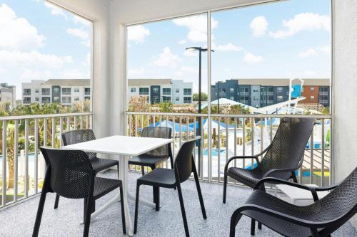 a balcony with a table and chairs and a view of a pool at Villatel Orlando Resort, Apartments by Marriott Bonvoy in Orlando