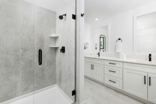 a white bathroom with a shower and a sink at Villatel Orlando Resort, Apartments by Marriott Bonvoy in Orlando