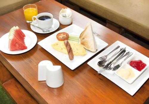 a table with plates of food and a cup of coffee at Sunday Telaga Terrace Boutique Resort in Pantai Cenang