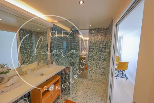 une salle de bain avec un lavabo et une douche avec un miroir dans l'établissement Eiffel Tower Splendor 4pp DREAM!, à Paris