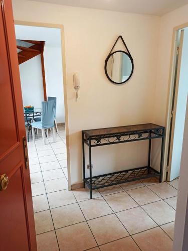 un couloir avec une table et un miroir mural dans l'établissement Duplex en maison, Terrasse, Garage, au calme, à Lyon