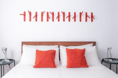 ein Schlafzimmer mit einem weißen Bett mit roten Kissen in der Unterkunft Pietrenere39 in Pozzallo