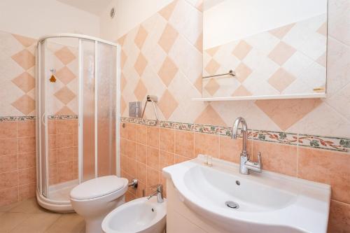 Un baño con lavabo, inodoro y ducha. en Casa Daniela, Vista Mare Sea View, en Chia