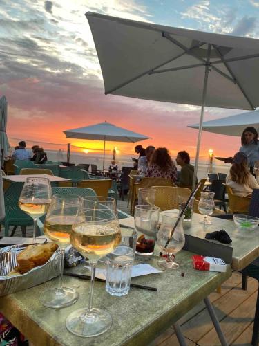 - une table avec des verres à vin et une vue sur l'océan dans l'établissement Appartement terrasse Malo à 2 pas de la plage, à Dunkerque