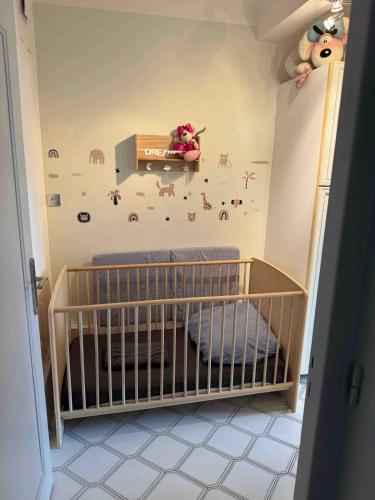 une chambre de bébé avec un berceau avec un mur avec des animaux dans l'établissement Appartement terrasse Malo à 2 pas de la plage, à Dunkerque