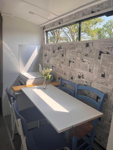 a table and chairs in a room with a window at Pépère, bus aménagé dans camping à la ferme in Arcomps