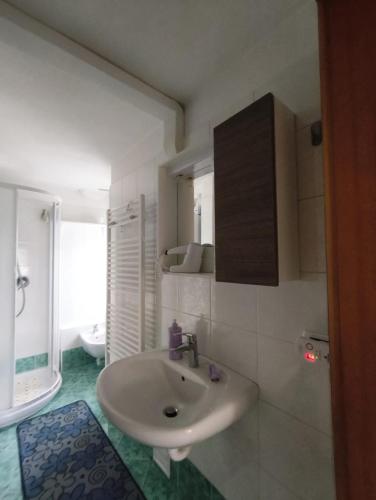 a white bathroom with a sink and a toilet at Casa Roberta in Falcade