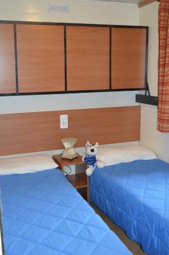 a bedroom with two beds and a stuffed animal on a table at Camping Royal in Pettenasco