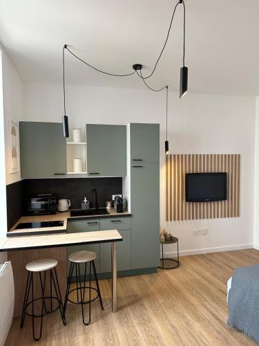 une cuisine avec un comptoir et des tabourets dans une pièce dans l'établissement Studio moderne/rue Encombe Vineuse- DABNB, à Limoges