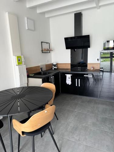 une cuisine avec une table, des chaises et une cuisinière dans l'établissement Nathôme 1, à Aleçon