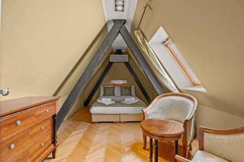 a bedroom with a bed and a chair in a attic at Villa Accione Opatija in Opatija