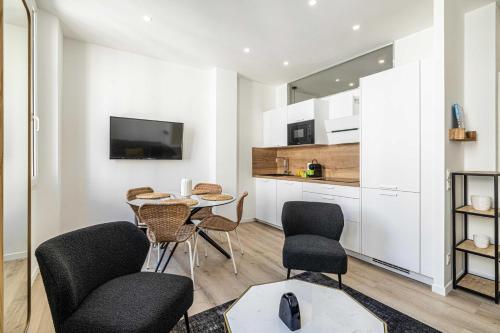 un salon avec une table et des chaises et une cuisine dans l'établissement Elegant 2 - Bedroom flat in Cannes, à Cannes