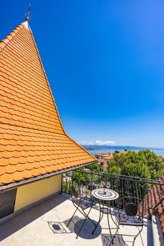 a balcony with an orange roof and a table and chairs at Villa Accione Opatija in Opatija