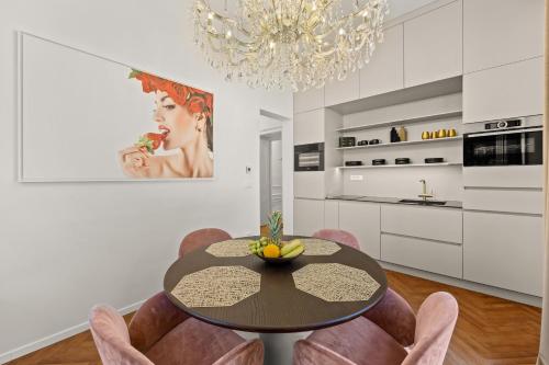 a dining room with a table and some pink chairs at Villa Accione Opatija in Opatija