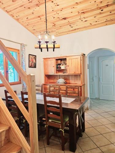 d'une salle à manger avec une table et des plafonds en bois. dans l'établissement Le Bastidon de Dudule, à Montagnac