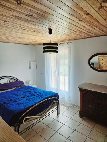 une chambre avec un lit et un plafond en bois dans l'établissement Le Bastidon de Dudule, à Montagnac