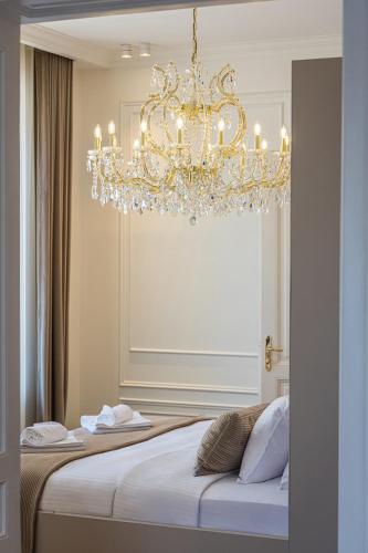 a chandelier hanging over a bed in a room at Villa Accione Opatija in Opatija