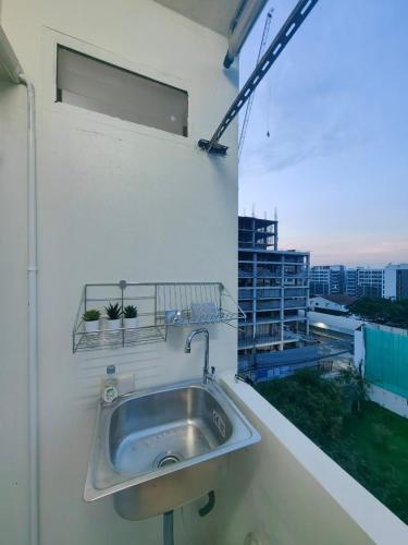 a sink in a white wall with a window at Secret Muji Vintage Building ห้องลับมูจิในตึกวินเทจ in Ban Song Hong