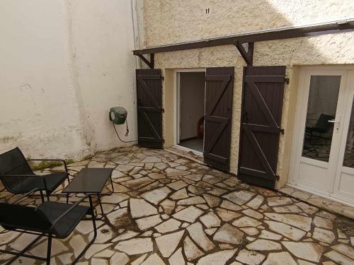 un patio vide avec deux chaises et une porte et une porte dans l'établissement Appartement Sauvian, à Sauvian