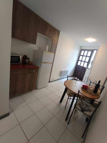 - une cuisine avec une table, une table et des chaises dans l'établissement Appartement Sauvian, à Sauvian