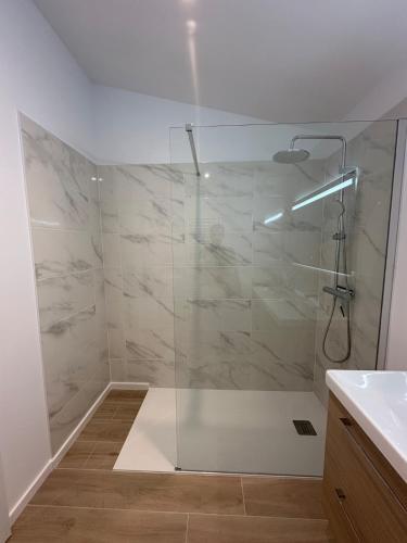 une douche avec une porte vitrée dans une salle de bain dans l'établissement Maison neuve entre la Plage, Aréna et de la gare des sables d'olonne, à Les Sables-dʼOlonne