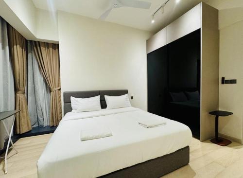 a bedroom with a large white bed and a couch at Star Residence KLCC By Cozy in Kuala Lumpur
