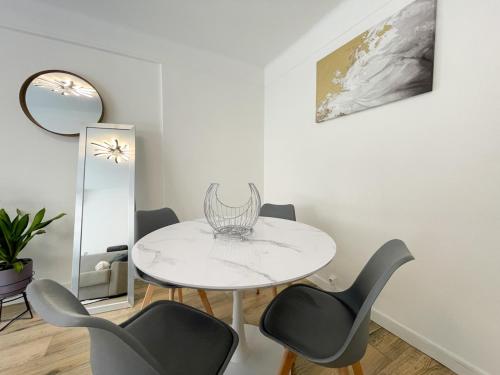 une salle à manger avec une table et des chaises blanches dans l'établissement Charmant studio proche mer, à Roquebrune-Cap-Martin