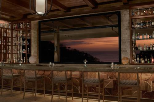 a bar with a view of the ocean at Nekajui, a Ritz-Carlton Reserve in Papagayo, Guanacaste