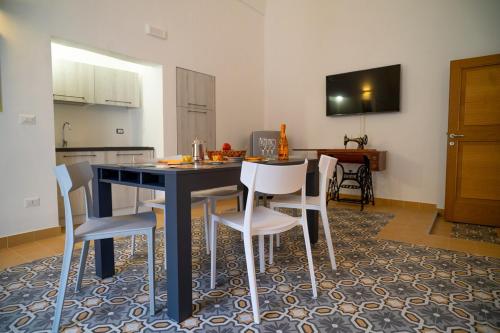 a kitchen with a black table and white chairs at View of the Tower, accommodation in the historic center and WiFi in Galatina