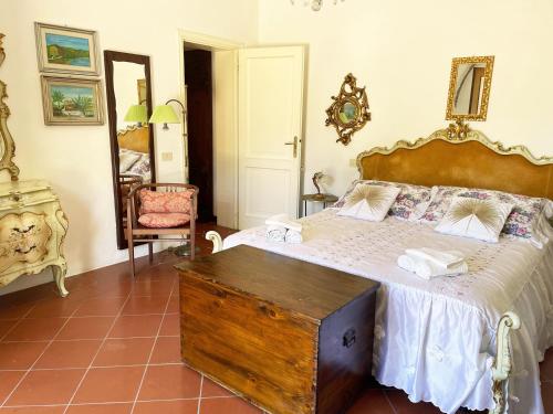 a bedroom with a large bed with a wooden trunk at 'Il Casale di Giova' Tuscan Farmhouse in Lucca