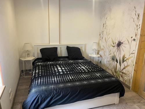 - une chambre avec un lit noir et 2 tables dans l'établissement Chez Claude, à La Celle-sous-Gouzon