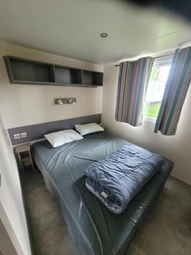 une chambre avec un lit dans une petite pièce dans l'établissement mobil home, à Lit-et-Mixe