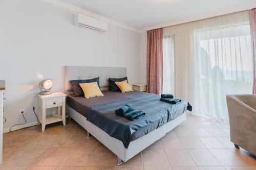 a bedroom with a bed and a large window at Созопол Sozopol- SOZOPOLIS - MORE SUN 2В in Sozopol