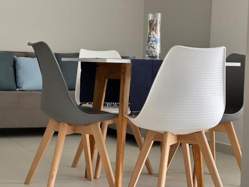 two white chairs and a table in a living room at Playa el Ángel Apartment in Pampatar