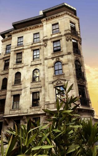 a large stone building with windows and a tree at GALATA M84 in Istanbul