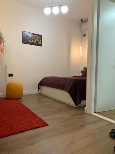 a bedroom with a bed and a red rug at Manga guesthouse in Gjirokastër