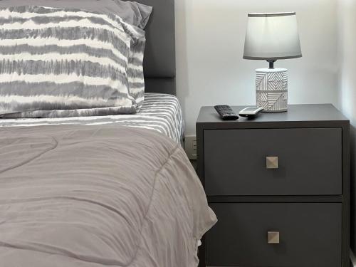 a bed with a nightstand with a lamp on it at Playa el Ángel Apartment in Pampatar