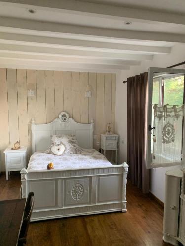 a bedroom with a white bed with a teddy bear on it at Maison belle vue in Réquista