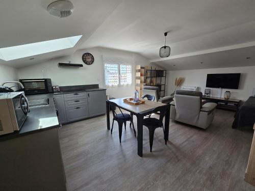 a kitchen and living room with a table and a living room at Au fil du bois in Contrexéville