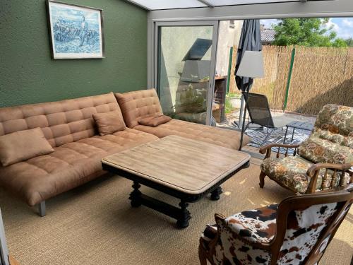 un salon avec un canapé, une table et des chaises dans l'établissement La Cabane, à Cruzilles-lès-Mépillat