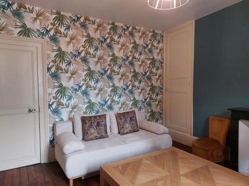 a living room with a couch and a wall at La maison Zola in Saint-Amand-Montrond