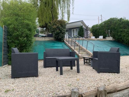 - un groupe de chaises et de tables en face d'une piscine dans l'établissement Le refuge du lac, à Changey